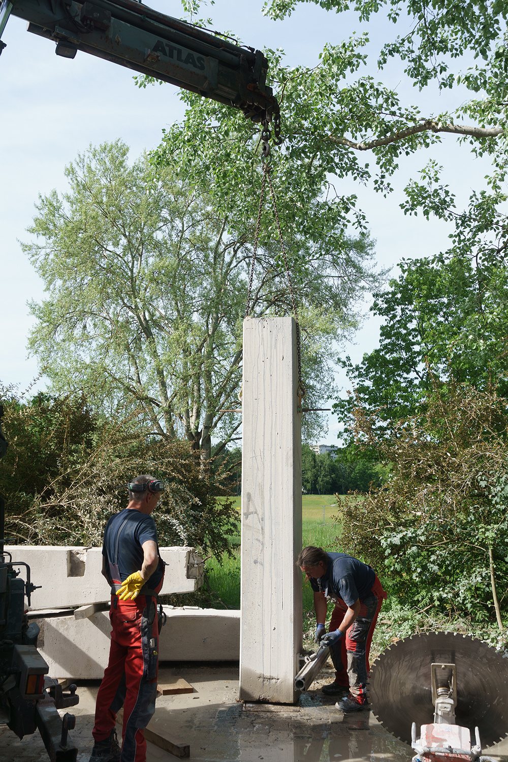 Wandsäge trennt einen Träger der Brücke, Monteur auf Gerüst