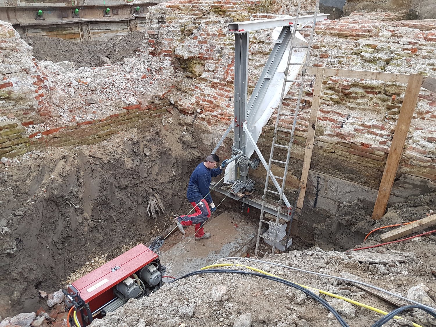 Monteur beim Seilsägeeinsatz an der Stadtmauer in der Baugrube