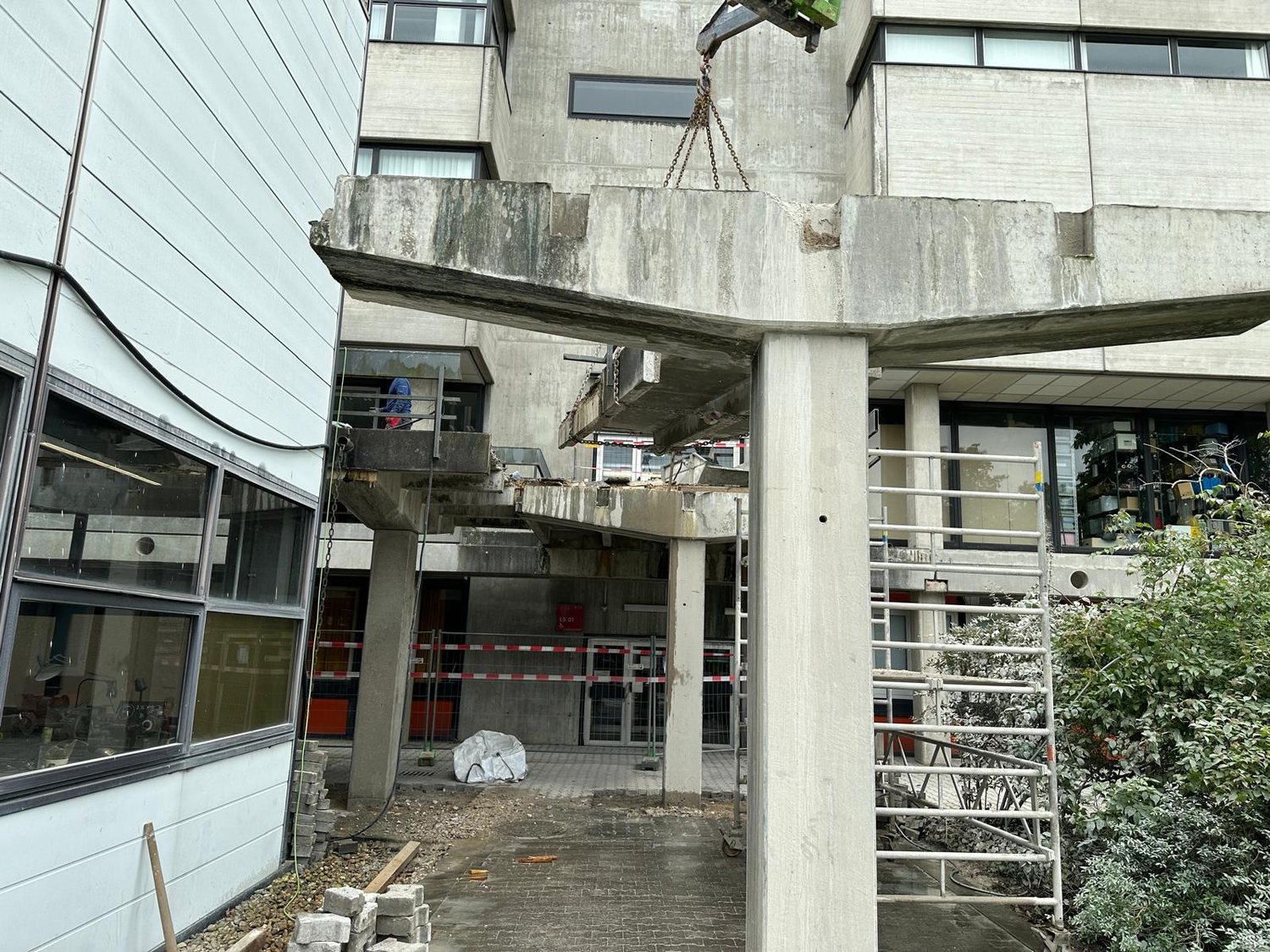 Herausgetrenntes Bauteil eines Verbindungsgangs wird am Kran gehalten